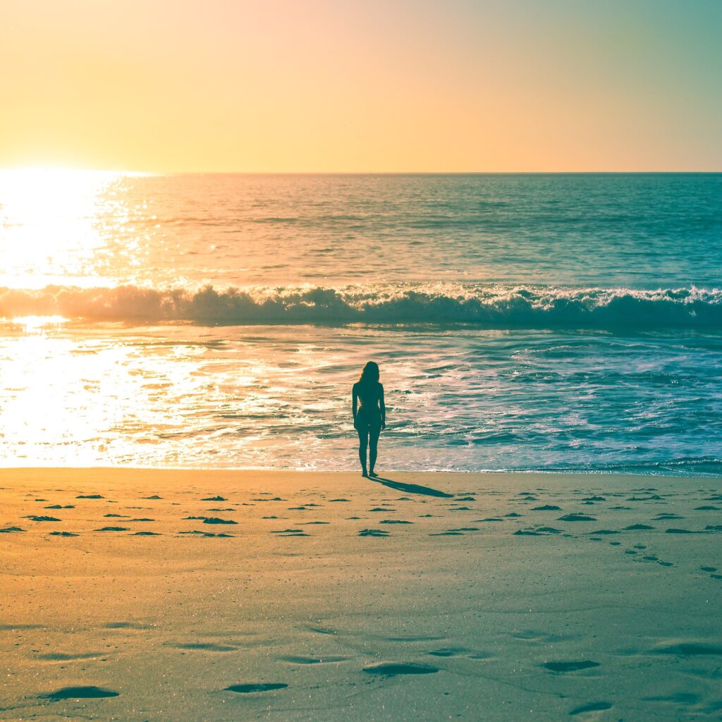 A woman staring out at the ocean on a warm, sunny, california afternoon