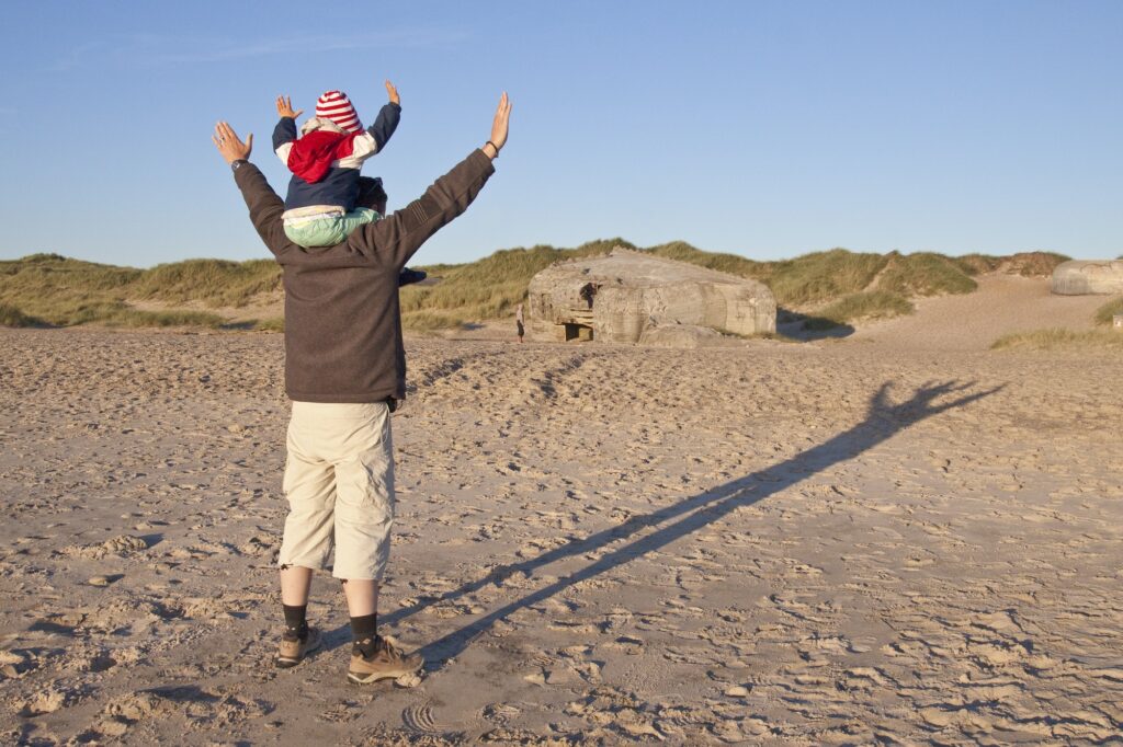 Denmark, Blavand, little girl and her father playing on the beach